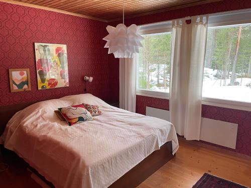 1 dormitorio con cama, ventana y lámpara de araña en House on Ingmarsö - in Stockholm archipelago, en Ingmarsö