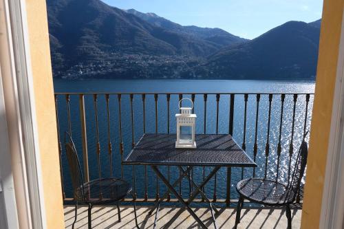 a table on a balcony with a view of a lake at Cozy Suites on the Lake - The House Of Travelers in Brienno