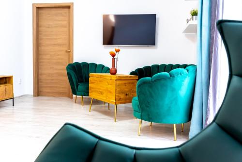 a waiting room with green chairs and a table at Thome Ego Flat in Cluj-Napoca