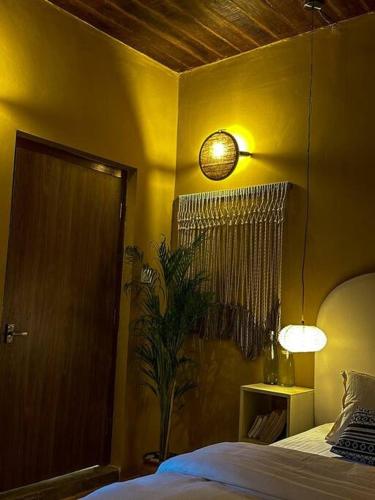 a bedroom with a bed and a lamp and a plant at The Melo pomelo courtyard. ( Right in between Thamel and basantapur durbar square) in Kathmandu