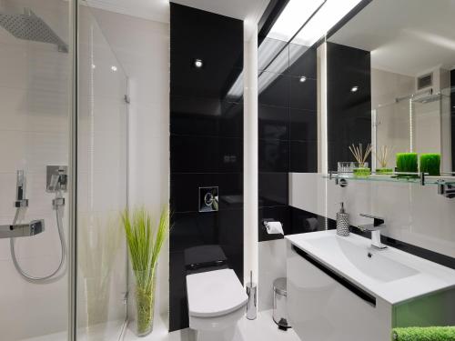 een badkamer met een toilet, een wastafel en een douche bij atHome in Krakau
