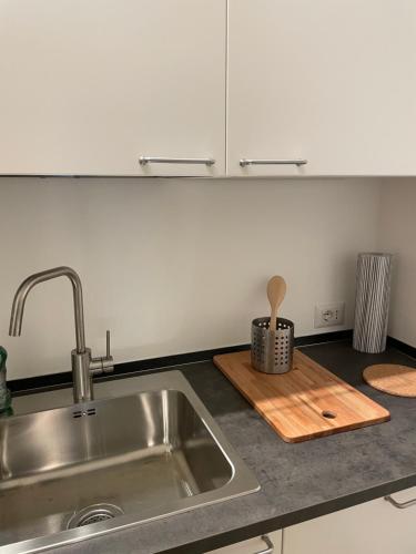 a kitchen counter with a sink and a wooden cutting board at Viale Pascoli Due in Cesenatico