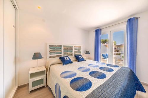 ein Schlafzimmer mit einem großen Bett mit blauen Kissen in der Unterkunft Bon Estar Apartment in Port d'Alcúdia