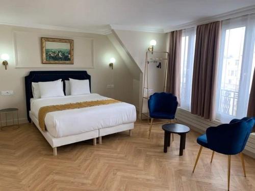 a bedroom with a large bed and blue chairs at Hotel Le Clery in Paris
