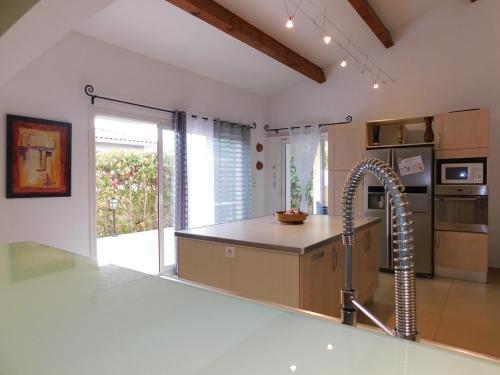 eine Küche mit einer Spüle und einem Wasserhahn in der Unterkunft Villa climatisée avec piscine et barbecue in Le Grau-du-Roi