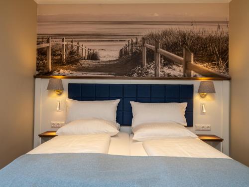 um quarto com uma cama com uma cabeceira azul em Tom's Hus Heiligenhafen em Heiligenhafen