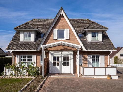 ein Backsteinhaus mit einer weißen Tür in der Unterkunft Tom's Hus Heiligenhafen in Heiligenhafen