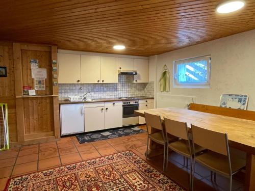 - une cuisine avec une table et des chaises en bois ainsi qu'un comptoir dans l'établissement Casa Acacia con giardino, à Avegno