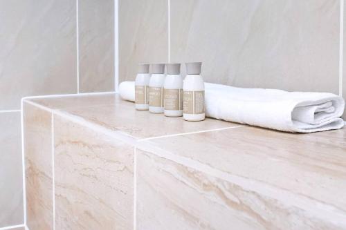 a counter with three bottles on it in a bathroom at Stylish London Bridge Apartment in London