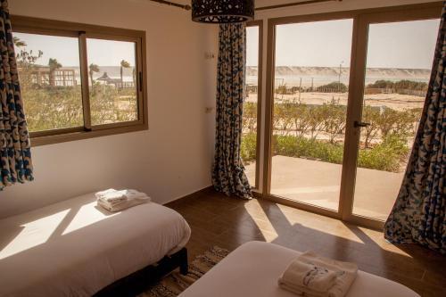 a bedroom with a bed and a window with a view of the beach at Dakhla Camp in Dakhla