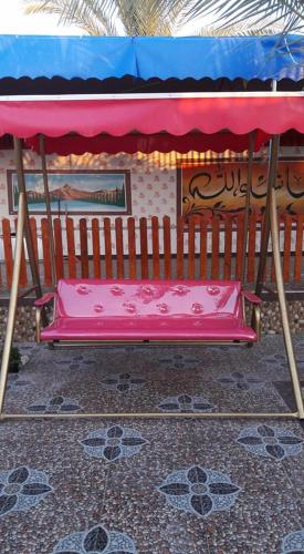 un banco rosa sentado junto a una valla en Furnished apartment for families only, en Khān Yūnis