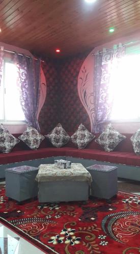 um quarto com duas janelas e um tapete vermelho em Furnished apartment for families only em Khān Yūnis