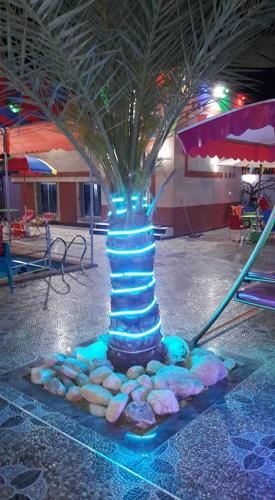 een blauwe lichtboom in een kamer met rotsen eromheen bij Furnished apartment for families only in Khān Yūnis