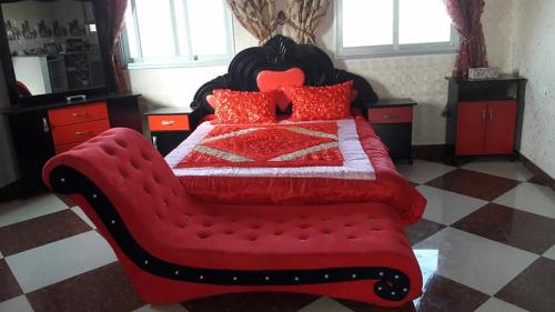 a bedroom with a red bed with a red comforter at Furnished apartment for families only in Khān Yūnis
