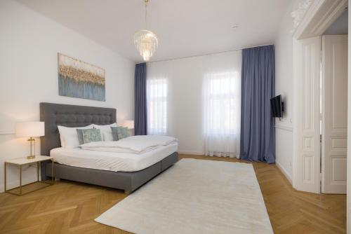 a white bedroom with a bed and a rug at RAFAEL KAISER - Premium Apartments - Contactless Check-In in Vienna