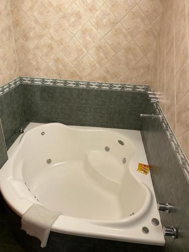 a white bath tub in a bathroom with a tile wall at Hotel Samay Huasi in Villa General Belgrano