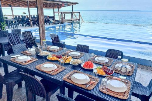 a table with food on it next to the water at Surigao Dream Beach Resort in Tigbao
