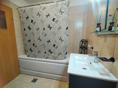 a bathroom with a shower curtain with bats on it at Lake view luxury apartment in Bucharest