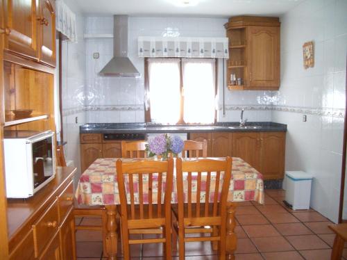 a kitchen with a table and chairs and a kitchen with a table and a kitchen at Apartments Aurora in La Robellada de Onis