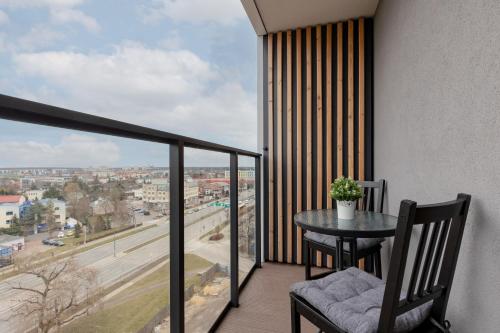 a balcony with a table and a view of a city at Pet-Friendly Studio Kokoryczki by Renters in Warsaw