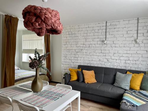 a living room with a couch and a table at M a t c h a in Ventspils
