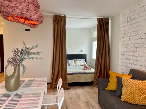 a living room with a couch and a bed in a bedroom at M a t c h a in Ventspils
