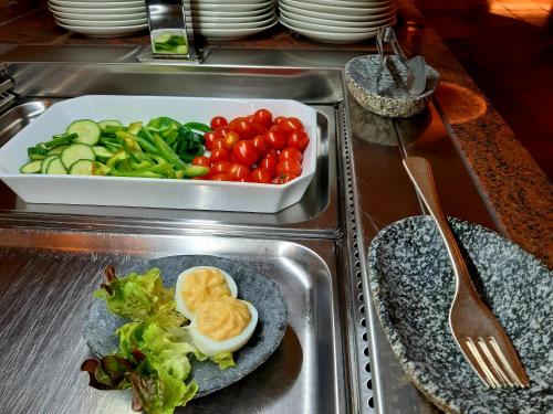 a sink with a plate of vegetables and a bowl of eggs at Hotel St. Georg in Zell am See