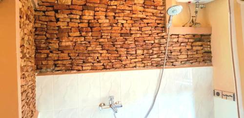 a stone wall in a bathroom with a shower at Keelan ace villas in Kampala