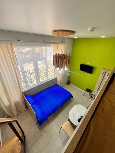 a bedroom with a blue bed and a green wall at Sport Hotel Terra in Ustʼ-Kamenogorsk