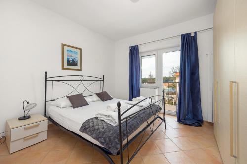 ein Schlafzimmer mit einem Bett und einem großen Fenster in der Unterkunft Apartmani Paliska in Pula