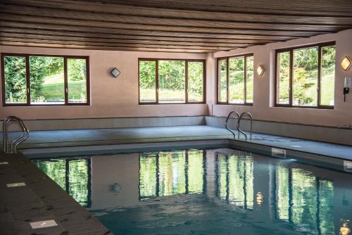 an indoor swimming pool with water in a house at Le Relais Du Marquis in Ittre