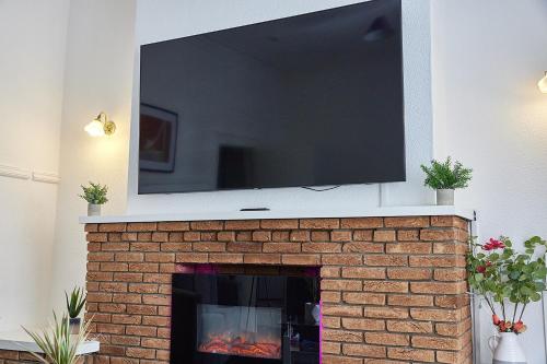 un televisor sobre una chimenea de ladrillo con un televisor encima en Pleasure Holiday Apartments, en Blackpool