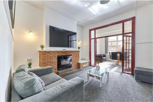 a living room with a couch and a fireplace at Pleasure Holiday Apartments in Blackpool