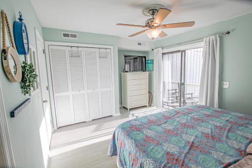 a bedroom with a bed and a ceiling fan at 3 Little Birds in Carolina Beach
