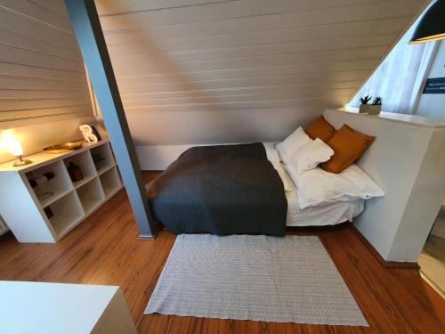a small bedroom with a bed in a attic at Zöld Relax Apartments in Budakeszi
