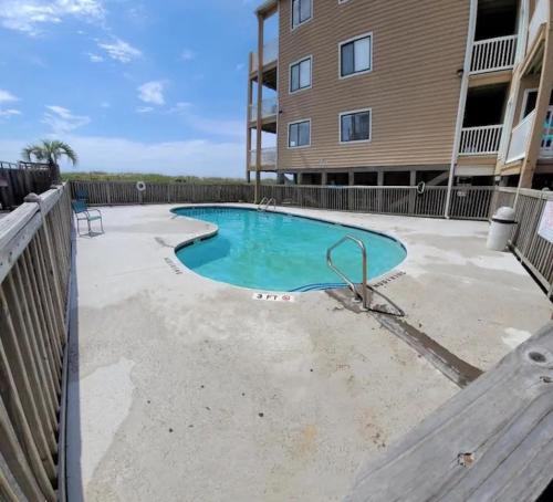 a swimming pool in front of a building at The Narrow Nest in Carolina Beach