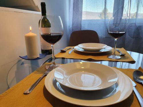 a table with two glasses of wine and a candle at Zöld Relax Apartments in Budakeszi