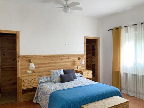 1 dormitorio con 1 cama con cabecero de madera en Casa Carmen una casa rural con piscina climatizada 