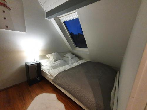 a small bed in a small room with a window at Zöld Relax Apartments in Budakeszi