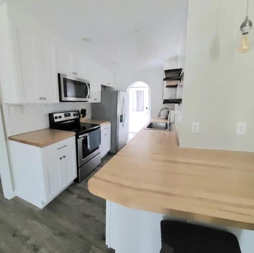 a white kitchen with a wooden counter top in it at Beachwood Bungalow B in Carolina Beach