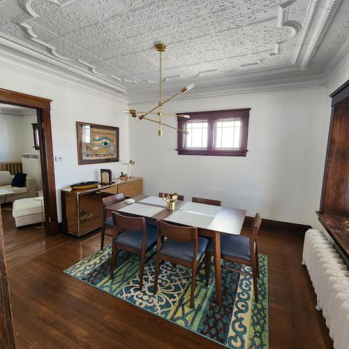 a dining room with a table and chairs on a rug at The Pandora Century Home in Kitchener