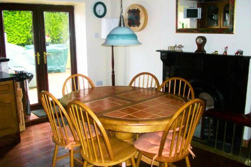 a dining room table with chairs and a blue lamp at Authentic Irish Cottage, Rural Ballymascanlon in Ballymascanlan