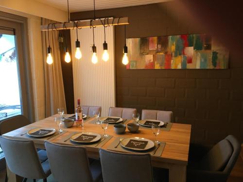 uma mesa de jantar com cadeiras e mesa em De Bosdreef - Hengelhoef - duplex met verwarmd openluchtzwembad em Aan de Wolfsberg