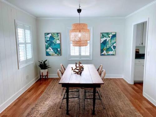 a dining room with a wooden table and chairs at Vitamin Sea in Carolina Beach