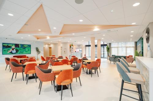 a dining area with tables and chairs in a cafeteria at Domitys La Cristal'In in Nancy