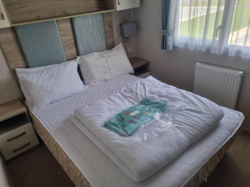 a large white bed with a bag on it at 8 Berth 3 Bed PG213 on the Golden Palm in Chapel Saint Leonards