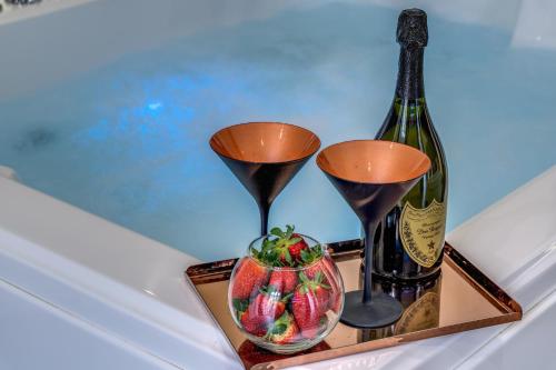 a tray with a bottle of wine and a bowl of strawberries at Gallery Suite Naples in Naples