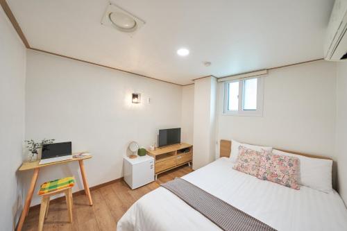 a bedroom with a bed and a desk with a television at K'STAY Sinchon in Seoul
