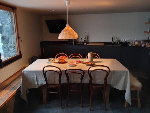 a dining room table with chairs and a white table cloth at LE REFUGE DE LUCE in Saint-Gervais-les-Bains