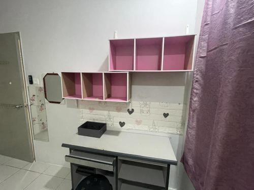 uma pequena cozinha com armários cor-de-rosa e um balcão em Cozy furnished new renovated condo( Platinum Teratai) em Kuala Lumpur